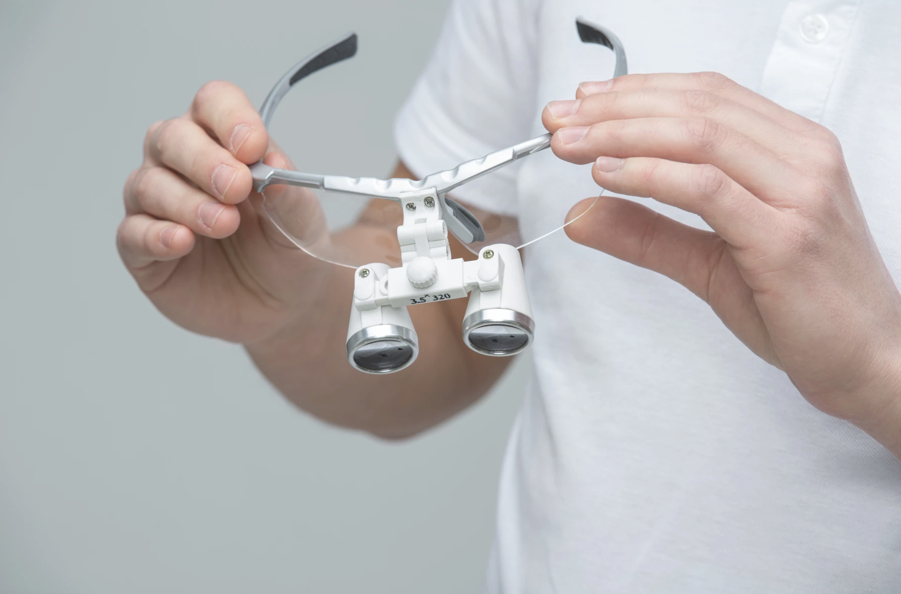 Praticien utilisant une loupe binoculaire pour un examen précis